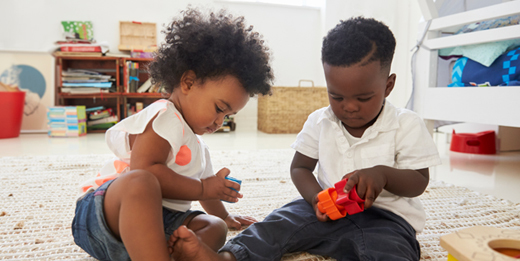Boy and girl playing with toys in a playroom.