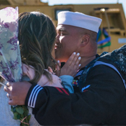 Service member kissing spouse.