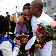U.S. Navy sailor embraces wife and family. 
