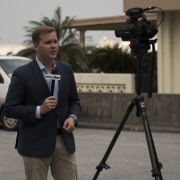 A reporter speaking into a microphone.