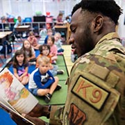 Service member reading a book to children