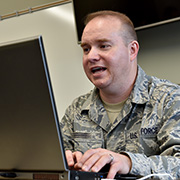 Service member typing on computer.