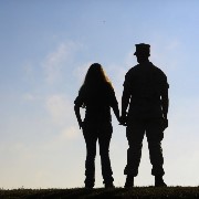Service member and his spouse hold hands
