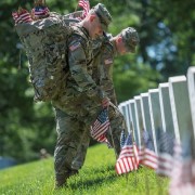 Soldiers place U.S. flags in headstones at Arlington National Cemetery, VA.