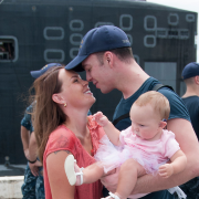 A sailor is greeted by his wife and baby daughter. 