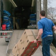 A man loads boxes onto a moving truck.