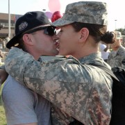 Service member and military spouse kissing.