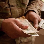 Service member holds cash in hands.