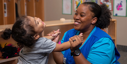 Child care provider playing with young girl