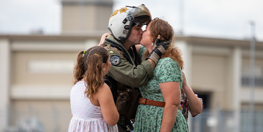 A Navy service member kisses his spouse