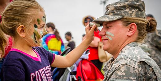 Girl paints face of service member