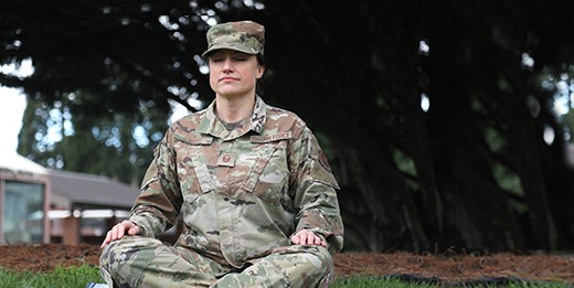 Woman soldier meditating in front yard.