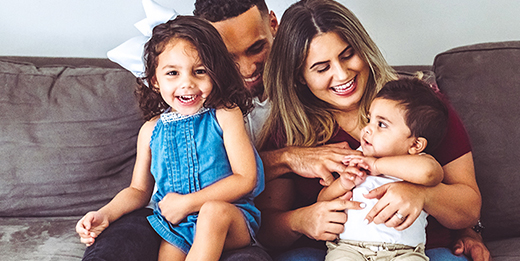 Family smiling and laughing on couch