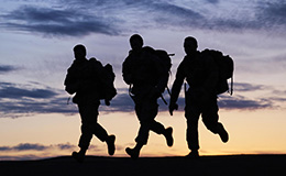 Soldiers running with backpacks