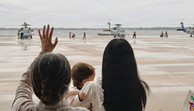 Family members wave to service members