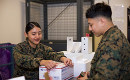 Service member places shipping label on package
