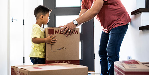 Father and son unloading moving boxes