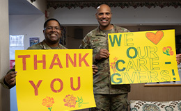 Soldiers holding signs of support for caregivers