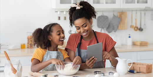 Parent and child make holiday cookies while taking a video call