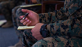 Service members fill out paperwork