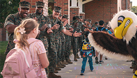 Service members greet school children