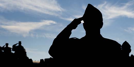 silhouette of service member saluting