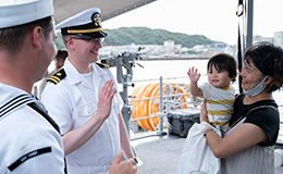 A service member waves hello to child