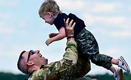 A service member greets a child