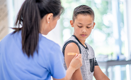 Nurse applies a bandage to a child.