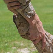 Service member grabbing other service member's hand in support