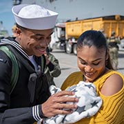Military couple holding baby smiling