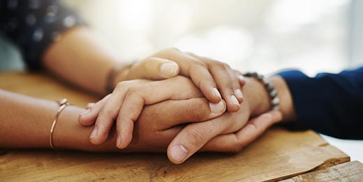 Two people holding hands in comfort