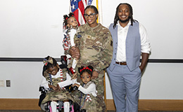 Service member poses with her family
