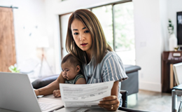 spouse with child on lap looking at computer