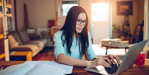 Woman at desk typing on a laptop