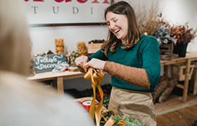 woman smiling curling holiday ribbons