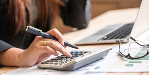 Woman typing on calculator