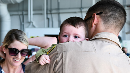 Service member hugging their baby son