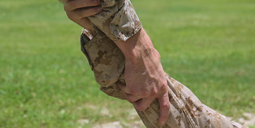 Service member grabbing other service member's hand in support