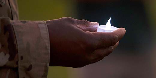 Service member holding candle