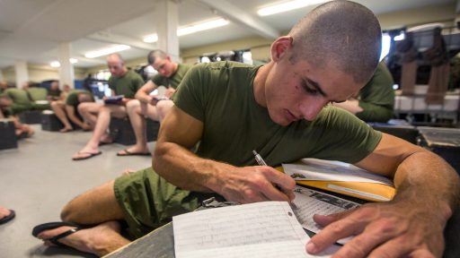 A service member writes letters home during free time