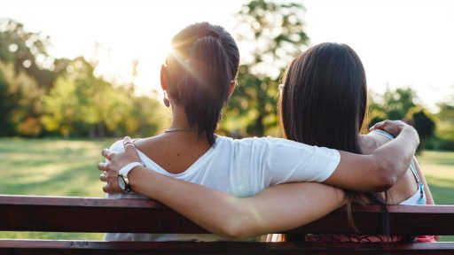 mother and daughter embracing rearview