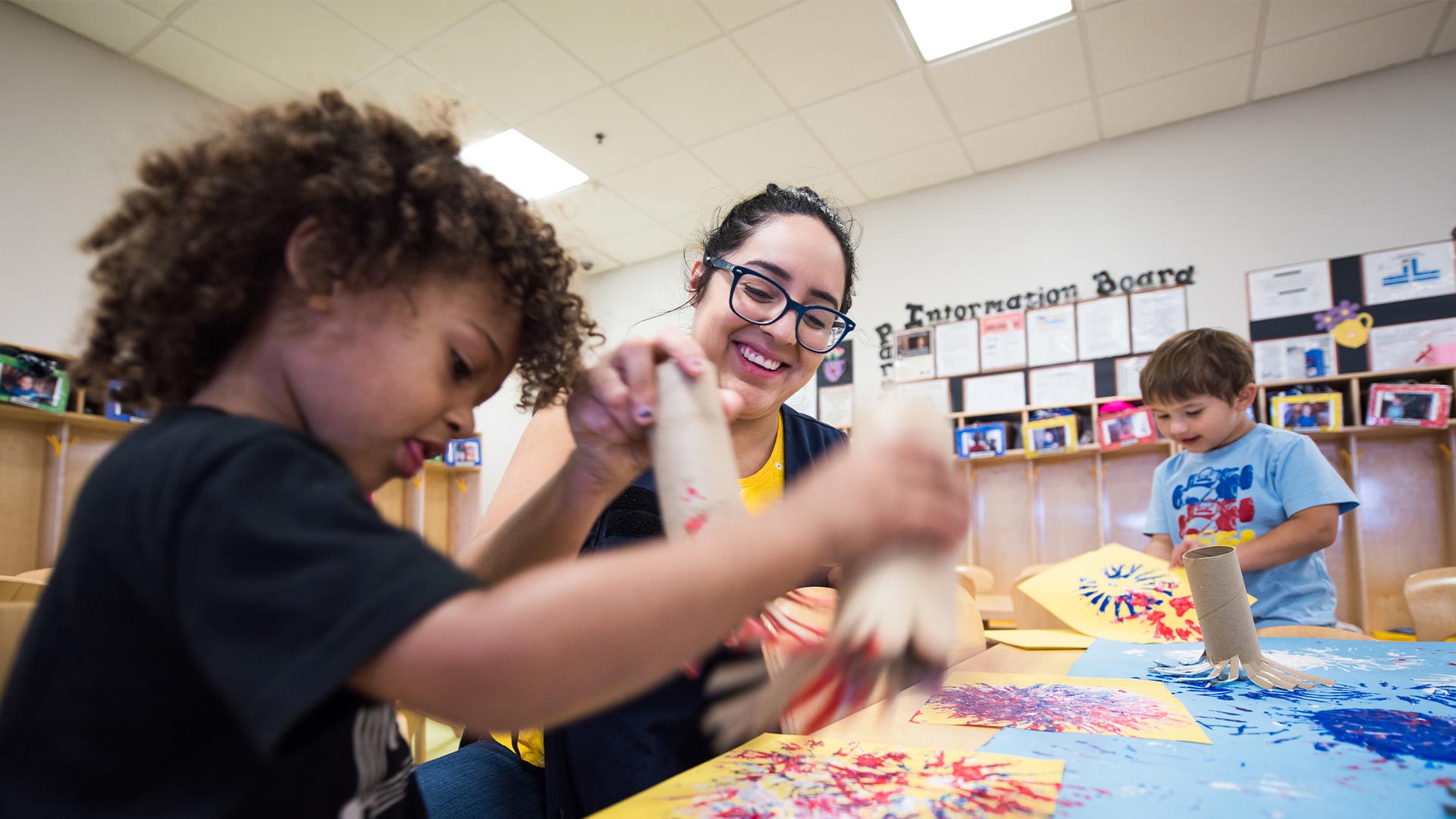 Teacher and two young students in classroom