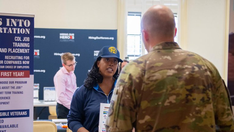 Service member speaks to representative at career summit