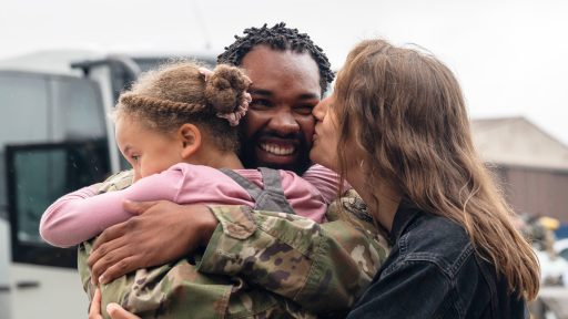 spouse and child hugging service member