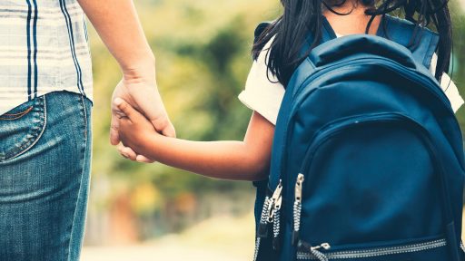 Woman holds child’s hand