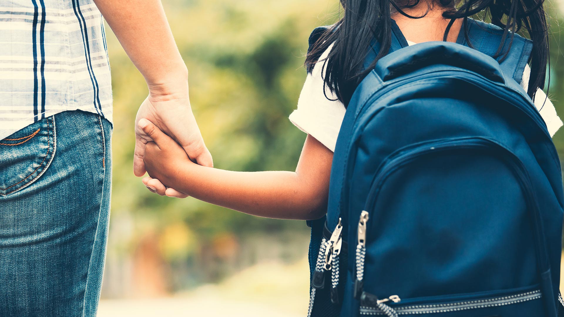Woman holds child’s hand