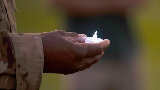 service member holding candle