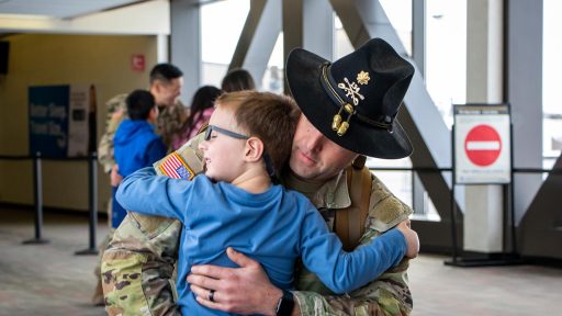 service member hugs child