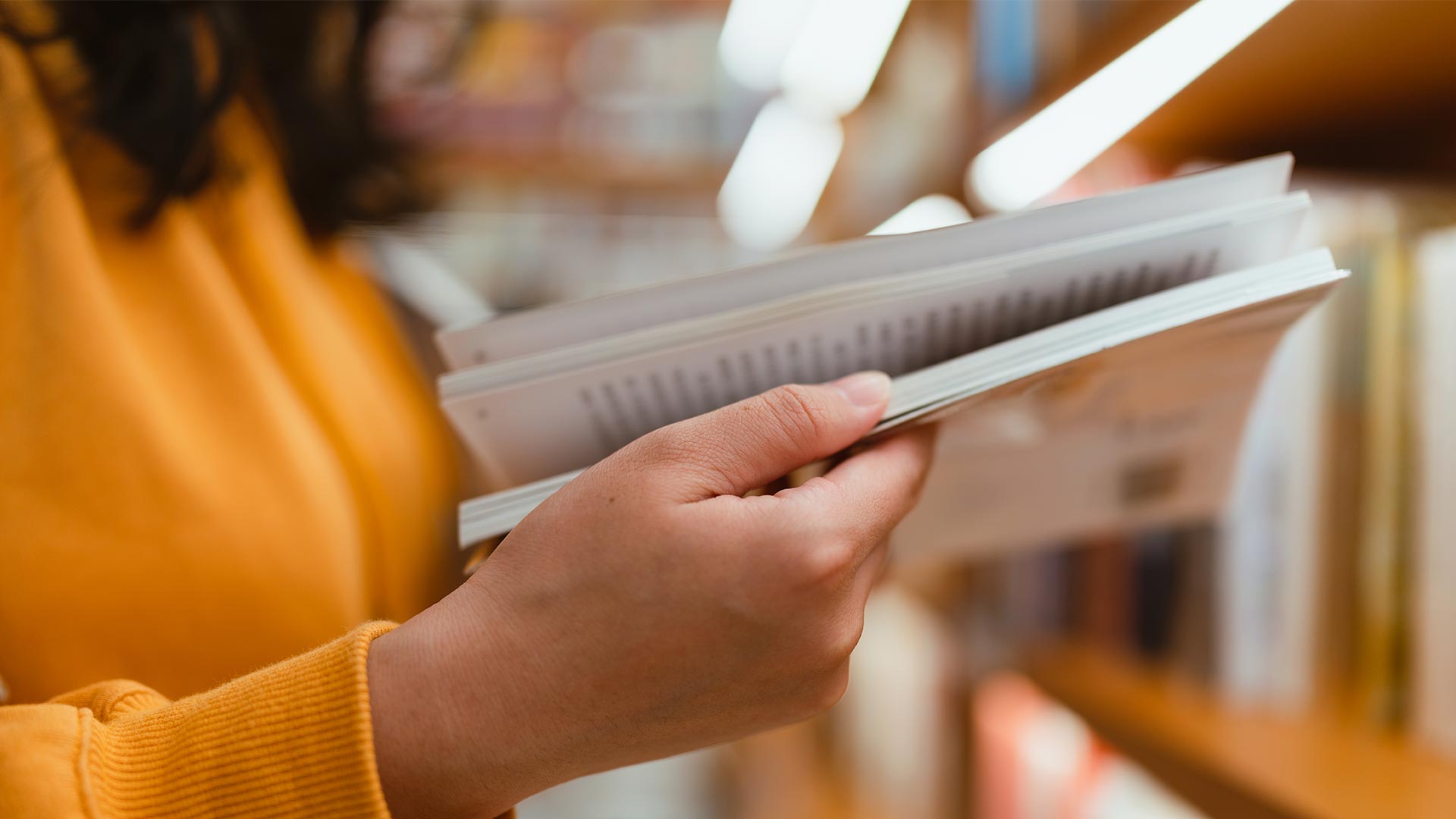 Woman reading book in school library